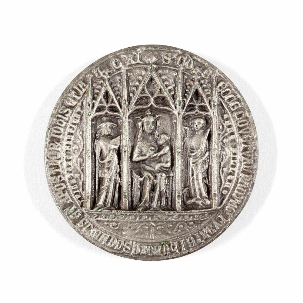 Round replica seal of Reading Abbey showing the Virgin Mary, baby Jesus, St James and St John.